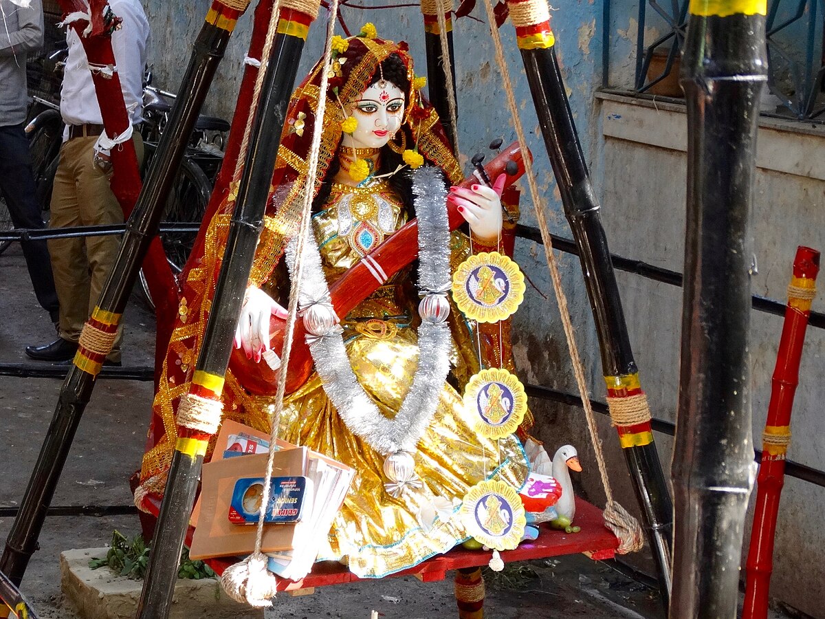 Goddess Saraswati idol with veena dressed in yellow sari for Vasant Panchami